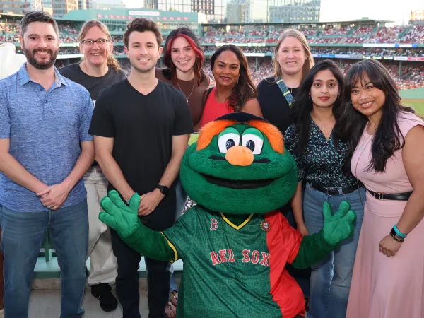 Corporate group photographed with a team mascot at a ballpark hospitality photo op