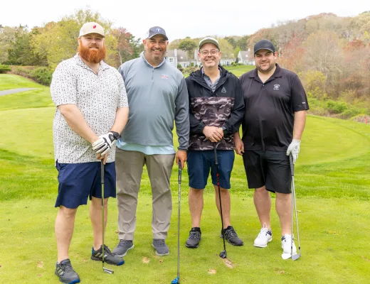 Golf tournament team photographed together with their clubs on the course