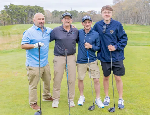 Golf tournament team photographed together with their clubs on the course