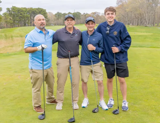 Golf tournament team photographed together with their clubs on the course