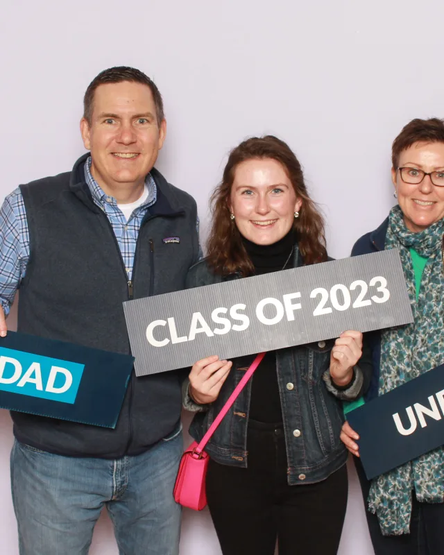 Graduate and family holding class-of signs at a university event