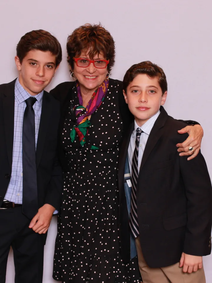 A grandmother posing with two boys in suits in the photo booth at a bar mitzvah