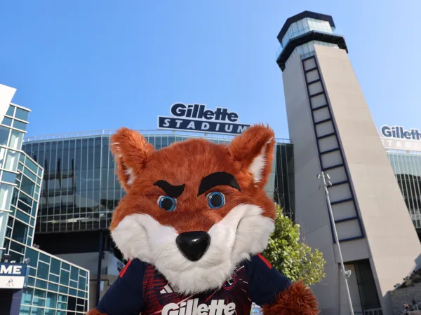 Team mascot photographed in front of the stadium at a gameday fan photo op
