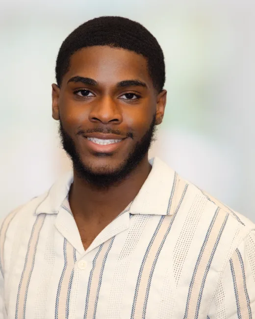 Business-casual headshot of a man on a softly lit background