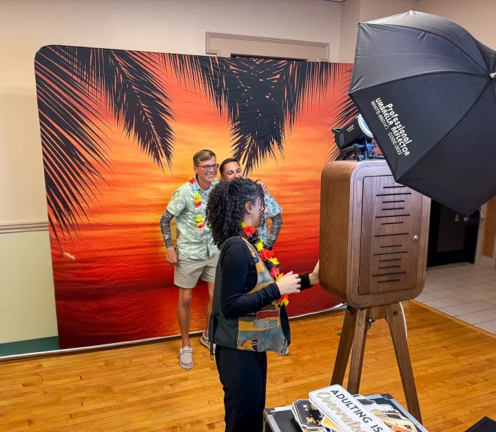 Guests posing at the Flashback booth in front of a tropical backdrop
