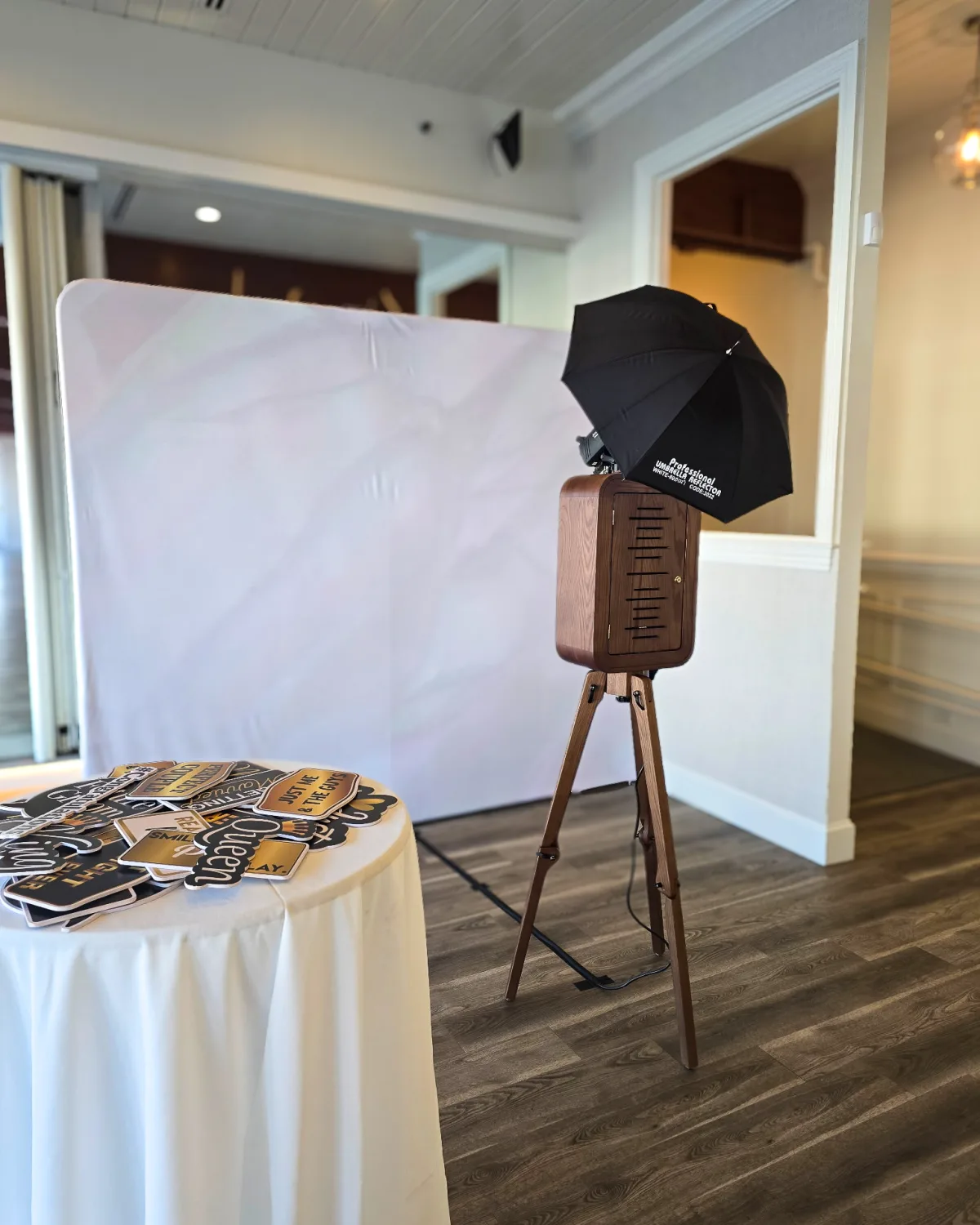 Flashback booth and prop table set up against a white backdrop at an elegant venue