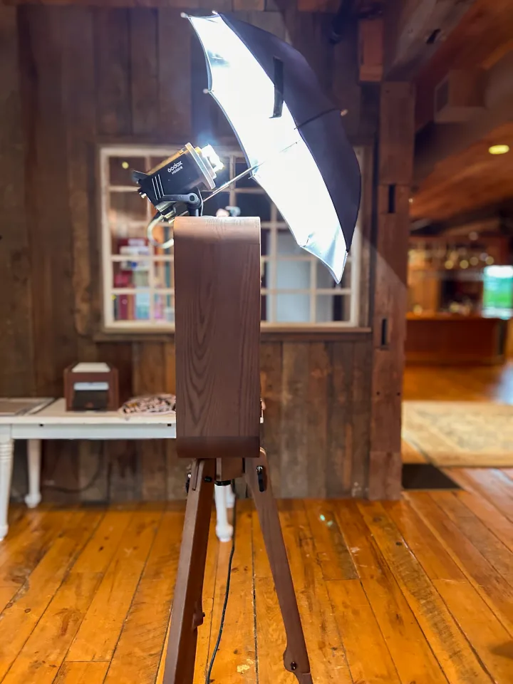 Flashback booth with studio umbrella beside a barn window