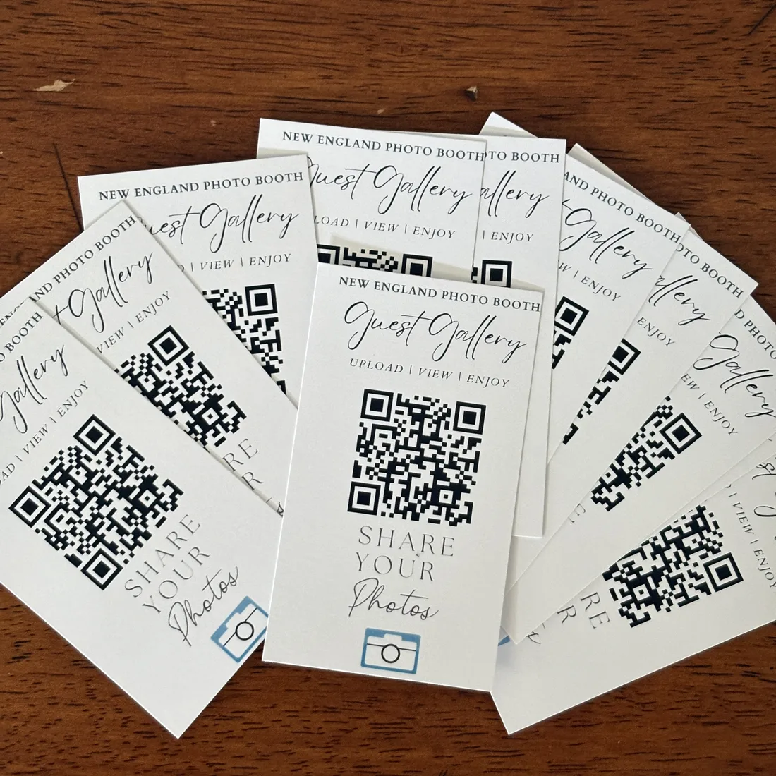 GuestView Guest Gallery QR cards fanned out on a wood table