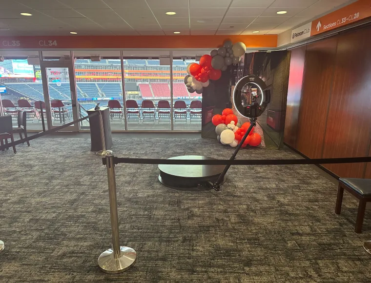 360 booth set up with balloon decor in a stadium suite overlooking the field