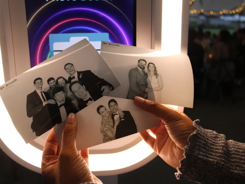 A guest holding fresh black-and-white photo booth prints