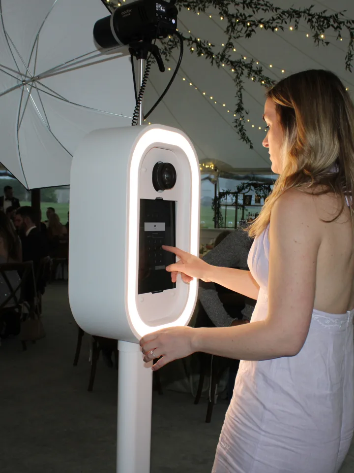 Bride using the LuxPod photo booth under a wedding tent