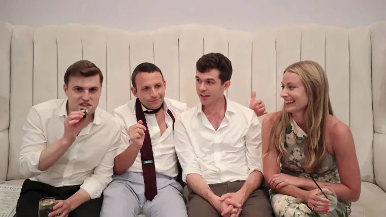 Four wedding guests laughing on the confessional couch