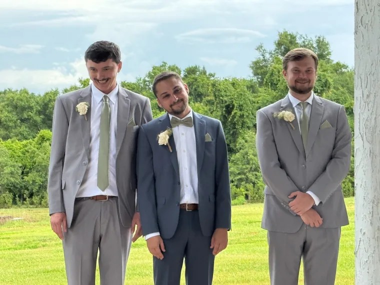 Groom and groomsmen in grey suits outdoors