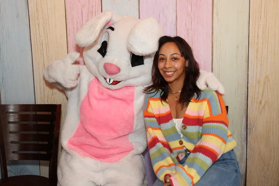 Guest posing with the Easter Bunny at a spring character photo op