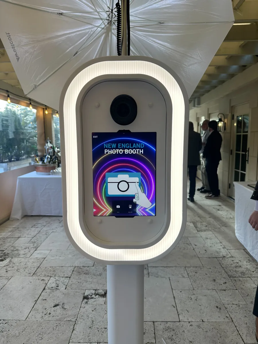The LuxPod with its ring light lit under a reception tent, guests behind it