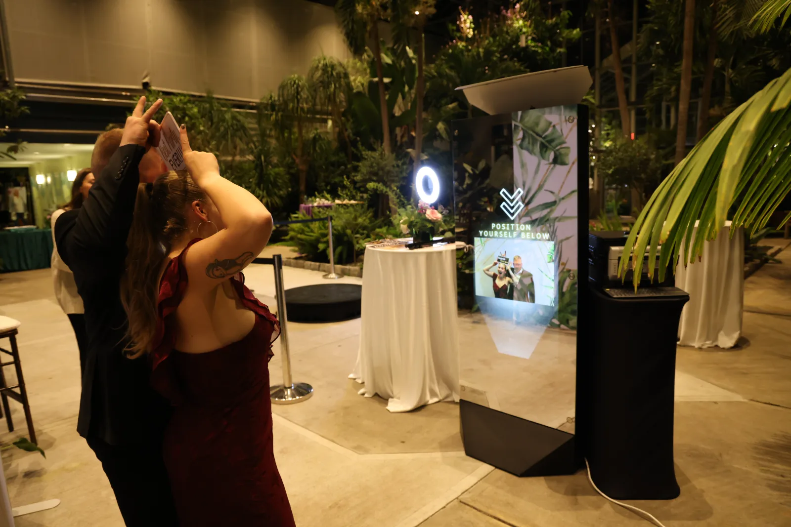 The Mirror Booth lit up in a garden atrium, ring light glowing