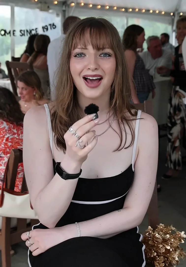 Guest speaking into the Confessional Booth clip mic at a tented reception