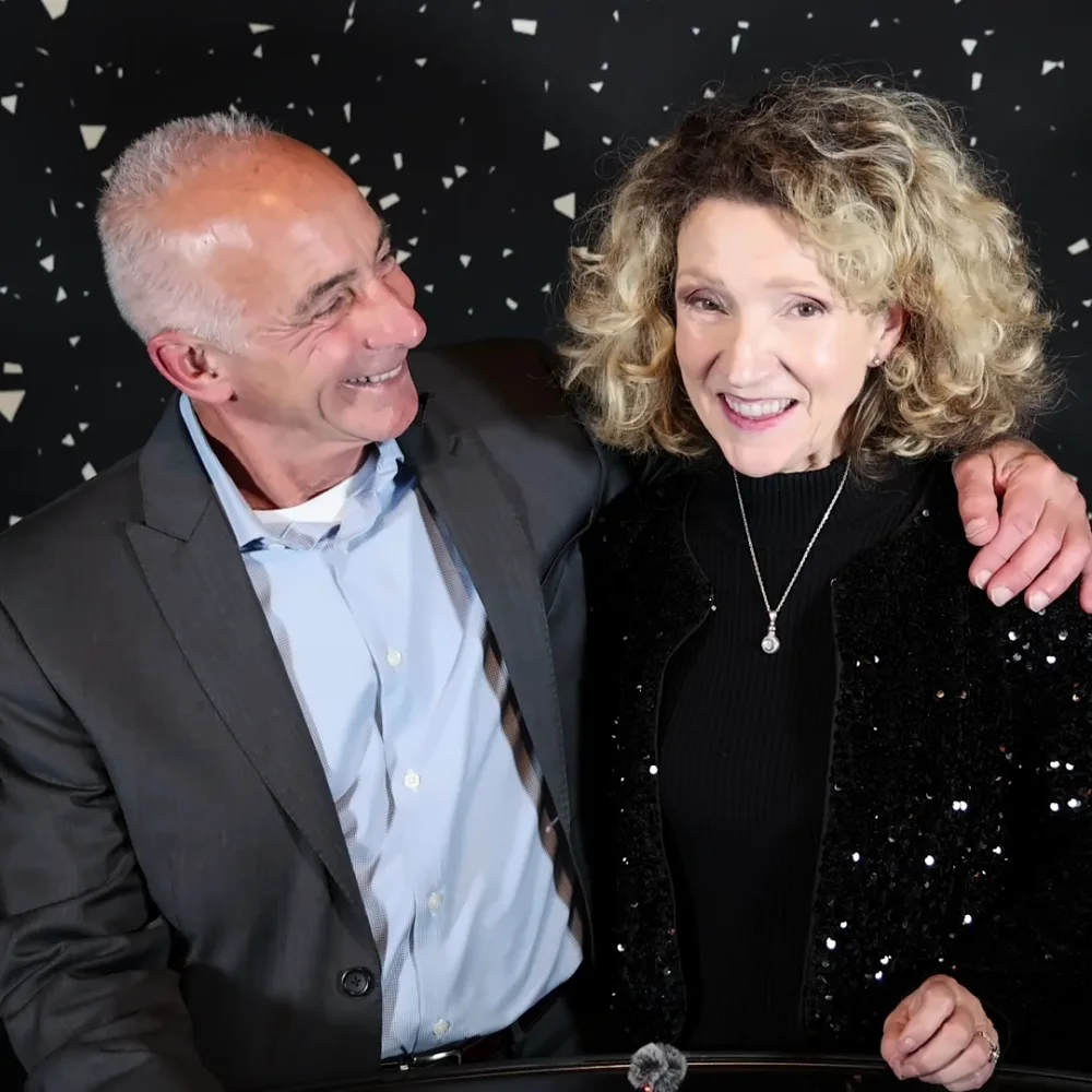 Couple smiling at each other while recording a Confessional Booth video message