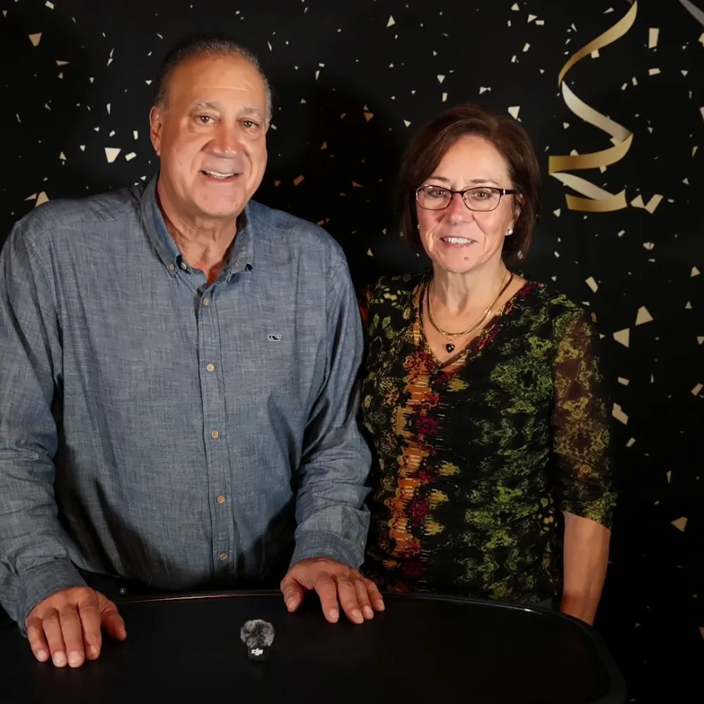 Couple recording a Confessional Booth video message in front of a confetti backdrop