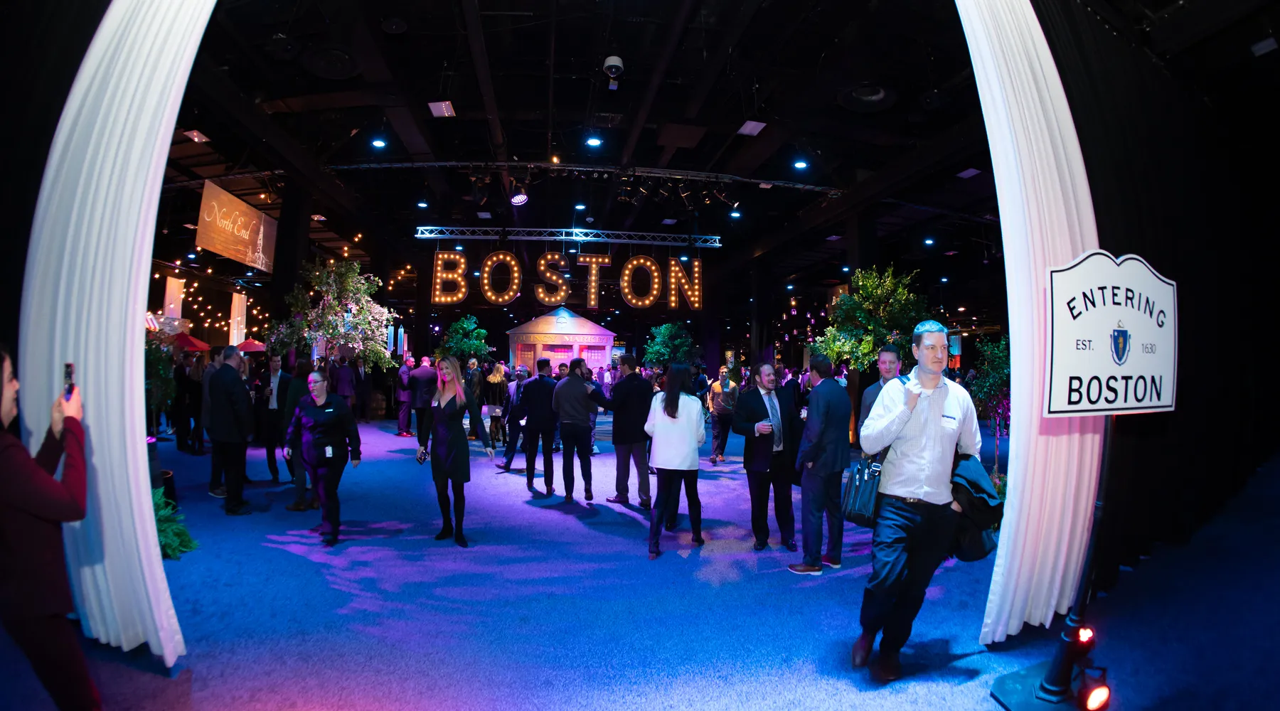 Guests walking through an Entering Boston archway at a Boston corporate gala